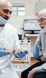 a dentist showing a patient their tooth replacement options