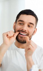 Man flossing in mirror