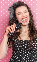 Woman trying to open a soda bottle with her teeth