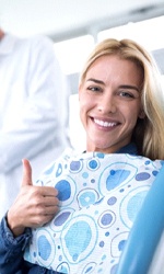 woman giving thumbs up in dental chair