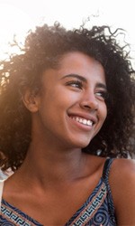 Woman walking outside and smiling on a sunny day 