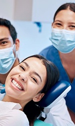 Dental patient posing for photo with dental team