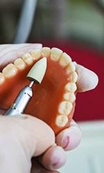 Lab tech filing dentures