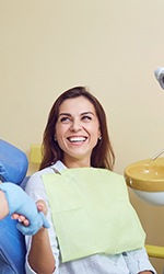 Woman smiling and shaking dentist’s hand
