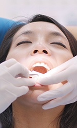 Dentist performing gum disease treatment on patient