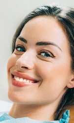 A woman smiling in the dentist chair