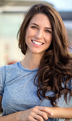 a woman grinning after undergoing a smile makeover