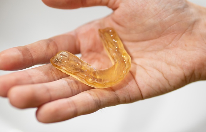 Close-up of hand holding nightguard for bruxism in Studio City