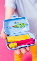 Person holding on-the-go oral hygiene kit