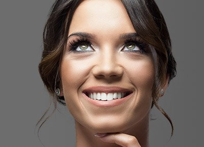 Woman with beautiful smile with her finger on her chin