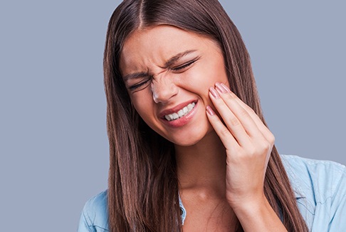 Woman holding jaw in pain