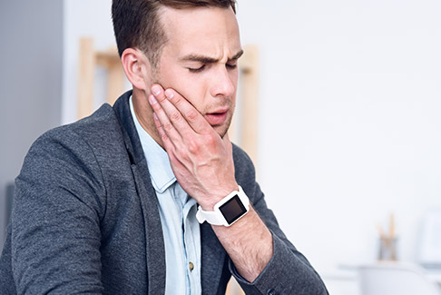 Man holding jaw in pain