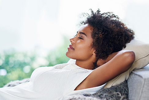 Relaxed woman with hands behind head