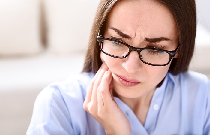 Woman holding jaw in pain