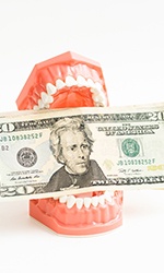 Money being held in a pair of fake teeth