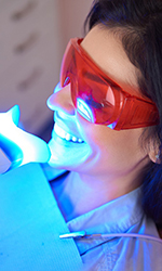 A closeup of a woman receiving teeth whitening treatment