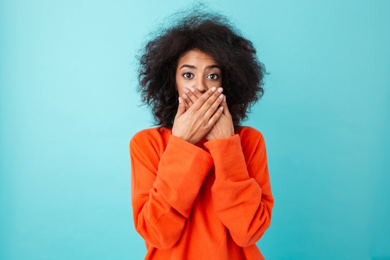 young woman covering her mouth