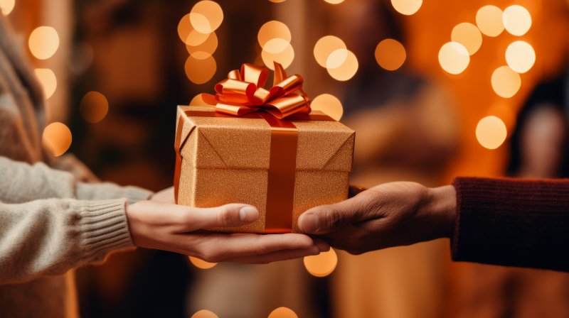 Two people holding a gift box 