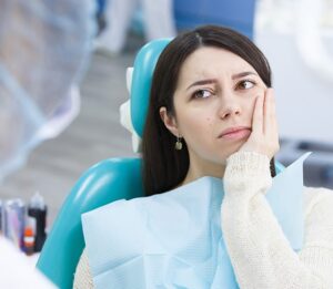 patient holding their mouth in pain